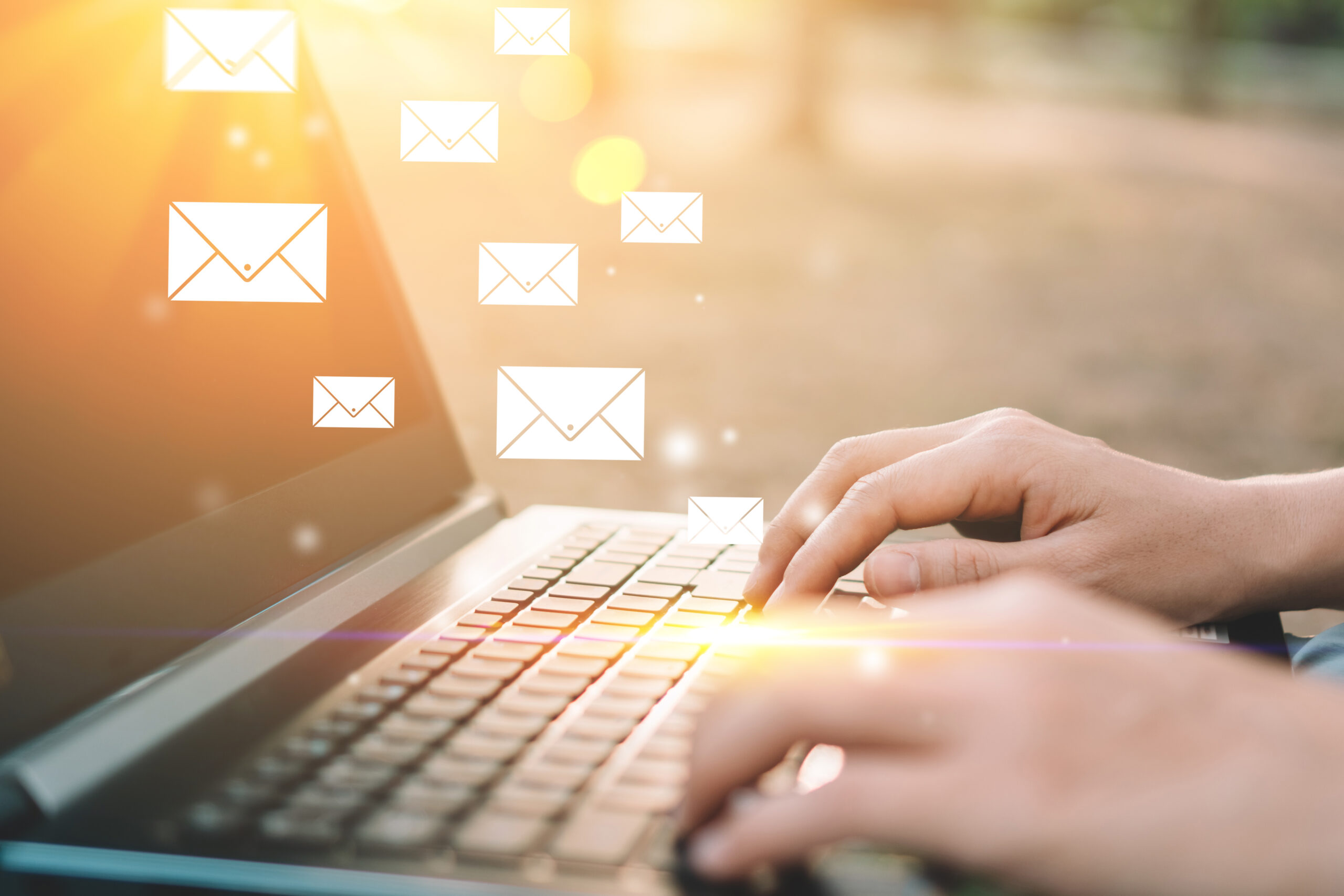 Woman hand using keyboard laptop in outdoor nature park background with email icon flying abstract. Technology business and freelance working concept. Vintage tone filter effect color style.