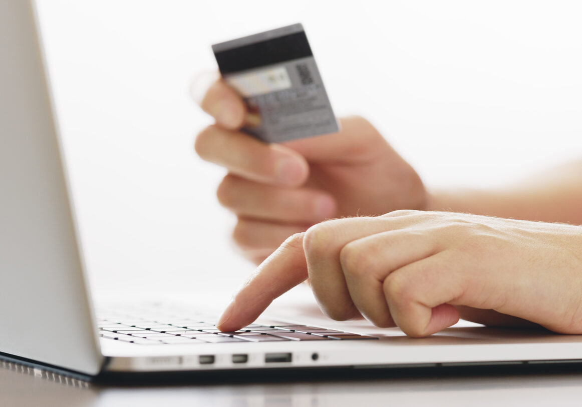 human  holding credit card and using laptop. Online shopping
